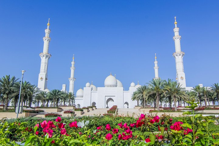 Experience the stunning architecture of Sheikh Zayed Mosque surrounded by lush gardens and vibrant blooms capturing the essence of Abu Dhabi's rich culture and history.